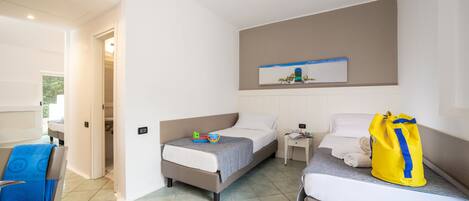 Habitación de hotel con dos camas, una silla, una mesita pequeña y una obra de arte colgada en la pared.