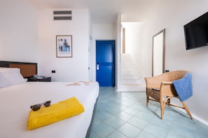 A hotel room with a bed, a chair, a TV, and a staircase. - TH Ostuni - Ostuni Marina Village (Ostuni)