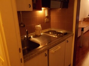 Standaard appartement, 1 slaapkamer | Privékitchenette | Een koelkast met diepvriezer, een kookplaat, kookgerei, borden en bestek