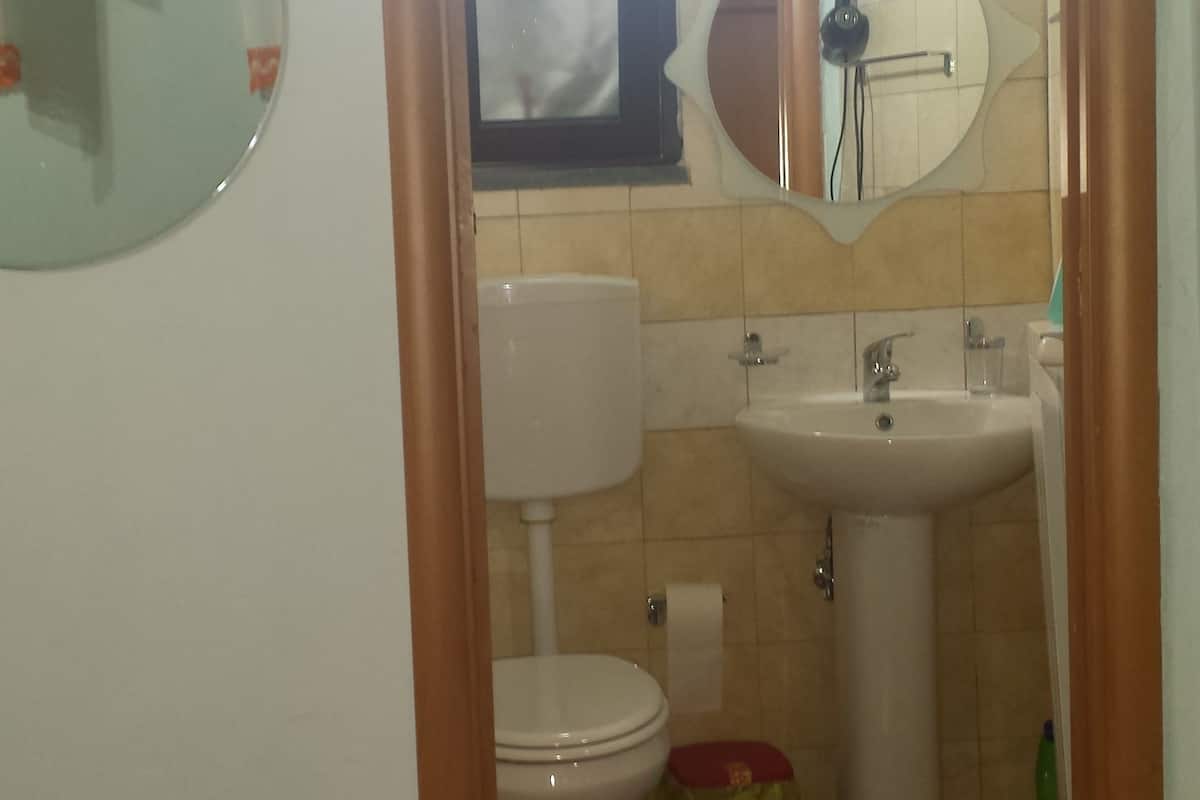 Ein Badezimmer mit Toilette, Waschbecken und Spiegel.