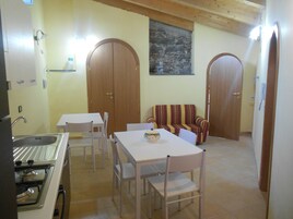 Un comedor con mesa y sillas, un sofá y una cocina con estufa.