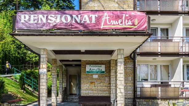 A building with a sign reading "Pensionat Amelia" and a covered entrance area.