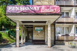 A building with a sign reading "Pensionat Amelia" and a covered entrance area.