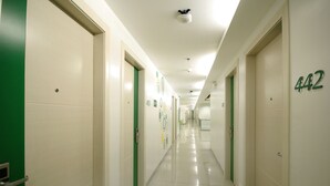 Un lungo corridoio ben illuminato con porte numerate da 401 a 442, che suggerisce la presenza di diverse camere.