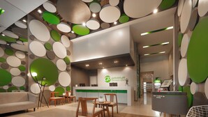 Una zona reception dal design moderno, con scrivania, area salotto e parete decorata con motivi circolari.