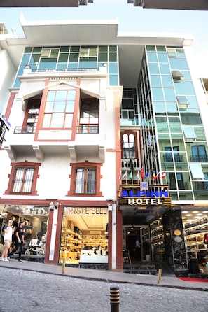 A hotel with a modern facade, a visible entrance, and a storefront with visible merchandise. - Alpinn Hotel Istanbul- Special Class (Istanbul)