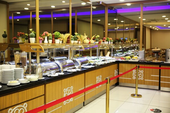 A buffet area with a variety of food items and a red rope barrier. - Alpinn Hotel Istanbul- Special Class (Istanbul)
