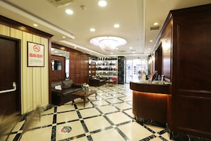 A hotel lobby with a check-in counter, seating area, and a shoe display. - Alpinn Hotel Istanbul- Special Class (Istanbul)