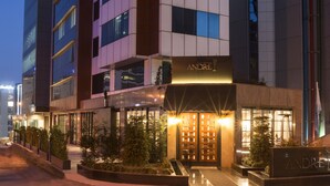 Un hôtel moderne doté d’une entrée imposante, de plusieurs étages et d’une façade bien éclairée.