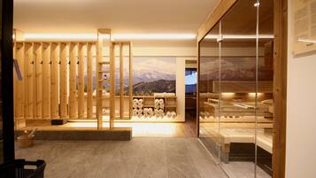 Relax in a serene spa room with a wooden sauna, wall-mounted shelf, and stunning mountain views.