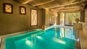 A swimming pool with a stone wall and a large vase. - Mas Salagros Ecoresort & Aire Ancient Baths (Vallromanes)