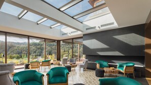 A spacious lounge with large windows, comfortable seating, and a modern fireplace. - Mas Salagros Ecoresort & Aire Ancient Baths (Vallromanes)