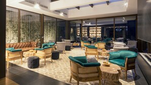 A spacious lounge area with multiple seating options, a skylight, and a view of a shoe store in the background. - Mas Salagros Ecoresort & Aire Ancient Baths (Vallromanes)