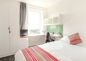 Espacio para trabajar con laptop y tabla de planchar con plancha