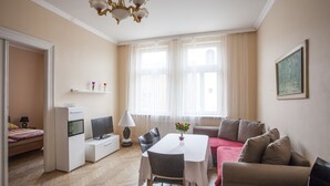 Una sala de estar moderna con mesa de comedor, sofá y mueble para TV.