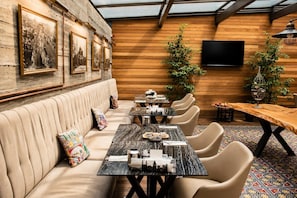 A restaurant interior with a long wooden bench, multiple tables, and chairs. - Hotel Miniature (Istanbul)