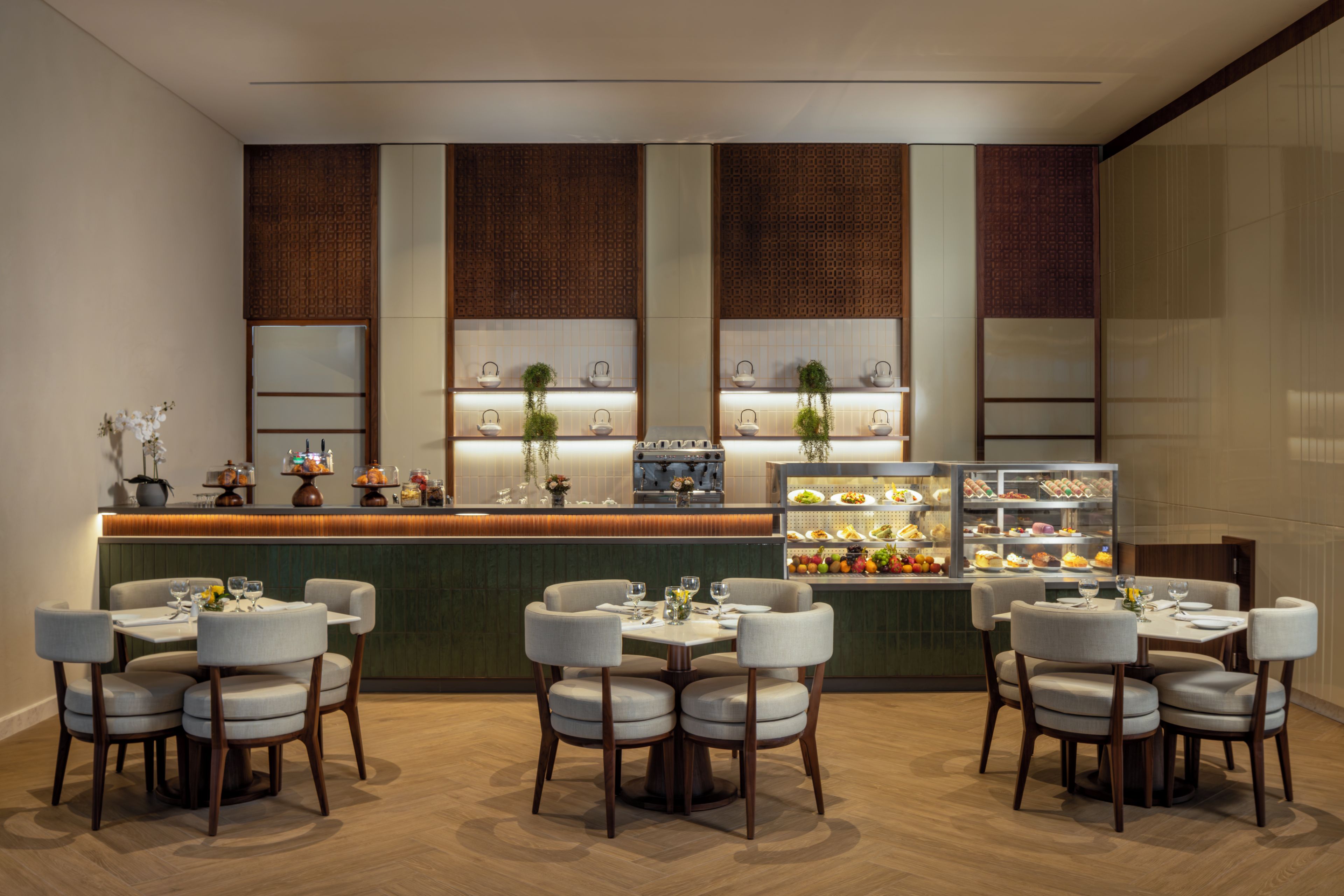 A restaurant with a counter, multiple seating areas, and a display case with food items.