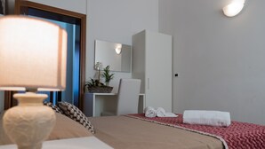 A hotel room with a bed, a bedside table with a lamp, a mirror, a wardrobe, and a red blanket. - Backpackers House Venice - Hostel (Venice)