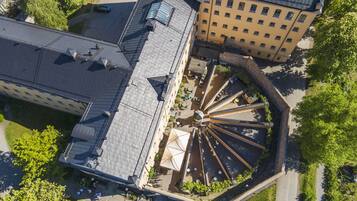 An aerial view of a building with a central courtyard, multiple balconies, and a mix of architectural styles.