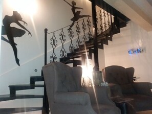 A staircase with ornate metal railings, two armchairs, and a wall with a silhouette decoration. - Pearl Hotel Istanbul (Istanbul)