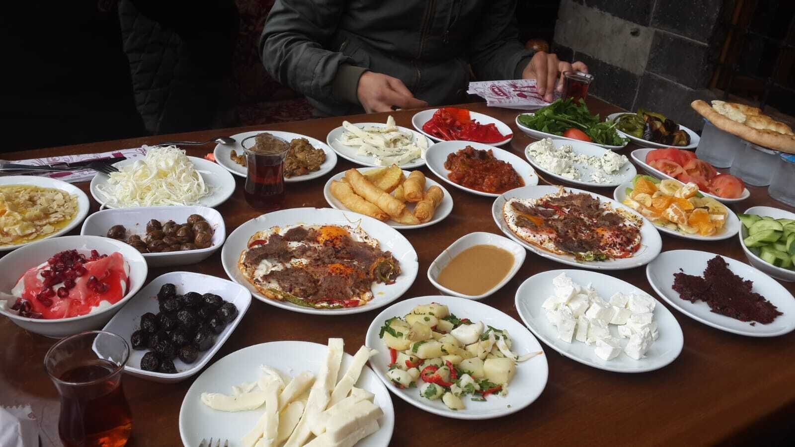 A table with various dishes, including salads, meats, and cheeses, suggesting a meal setting.