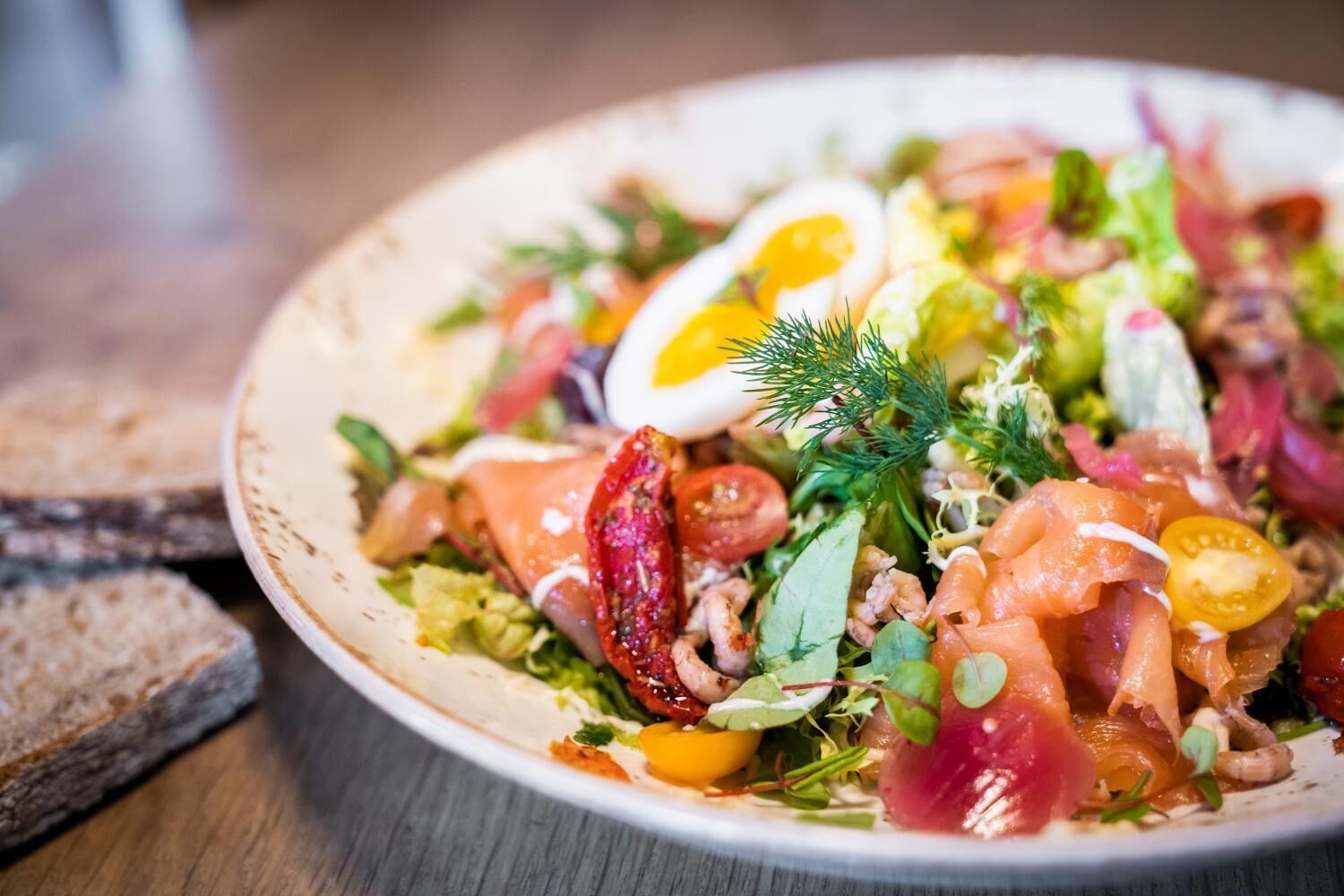 A plate of food with various ingredients including eggs, tomatoes, and greens.