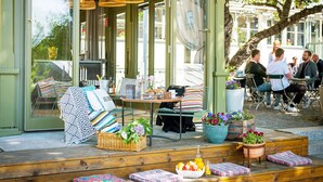 An outdoor seating area with tables, chairs, and potted plants. - STF Långholmen Hostel (Stockholm)