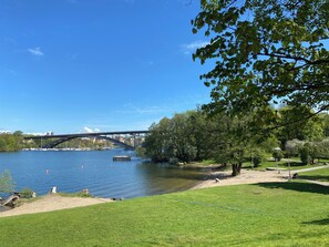 Un parc avec une rivière, un pont et des bateaux.