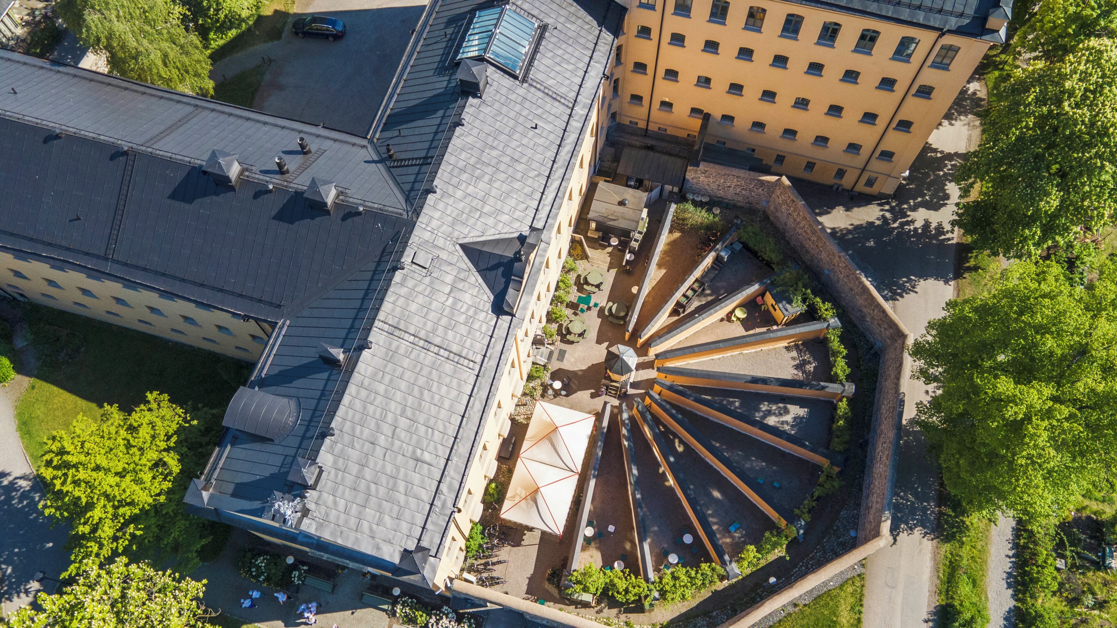 An aerial view of a building with a central courtyard, multiple balconies, and a mix of architectural styles.