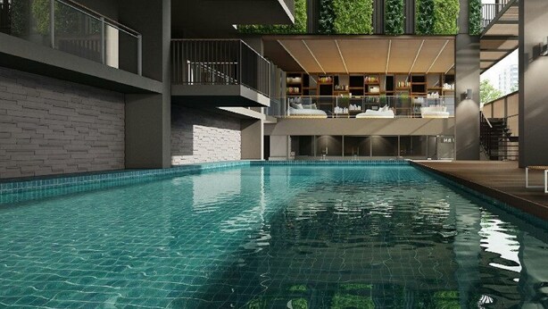 A modern indoor swimming pool with a clear view of the pool area, a brick wall, and a balcony with a railing. - Happy 3 (Bangkok)
