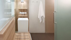 A modern bathroom with a wooden vanity, a white bathtub, and a glass shower enclosure. - Happy 3 (Bangkok)