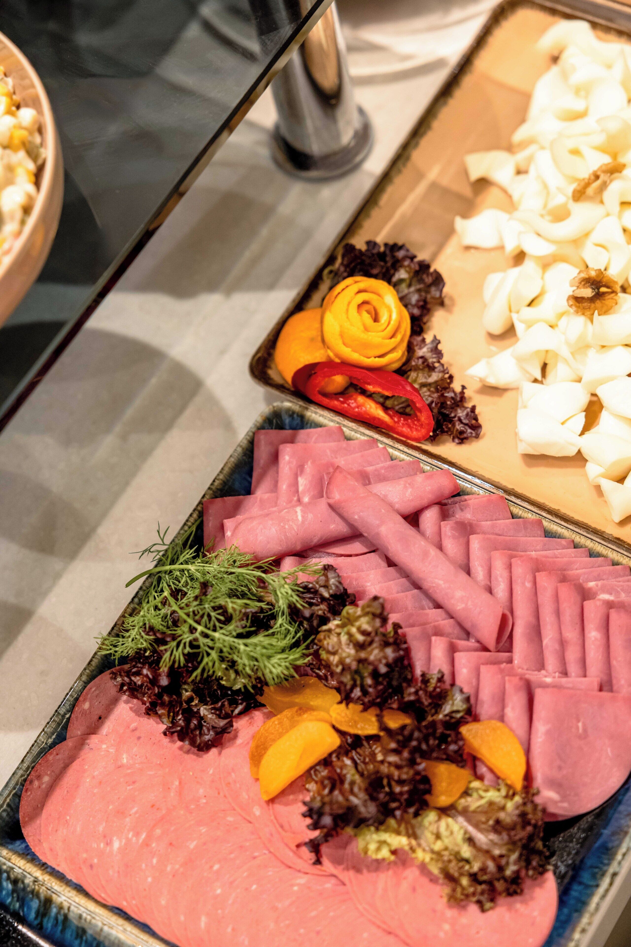 Buffet amb diferents aliments, com ara embotits, fruita i verdures.