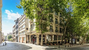 En historisk bygning med detaljeret arkitektur, store vinduer og en brostensbelagt gade.