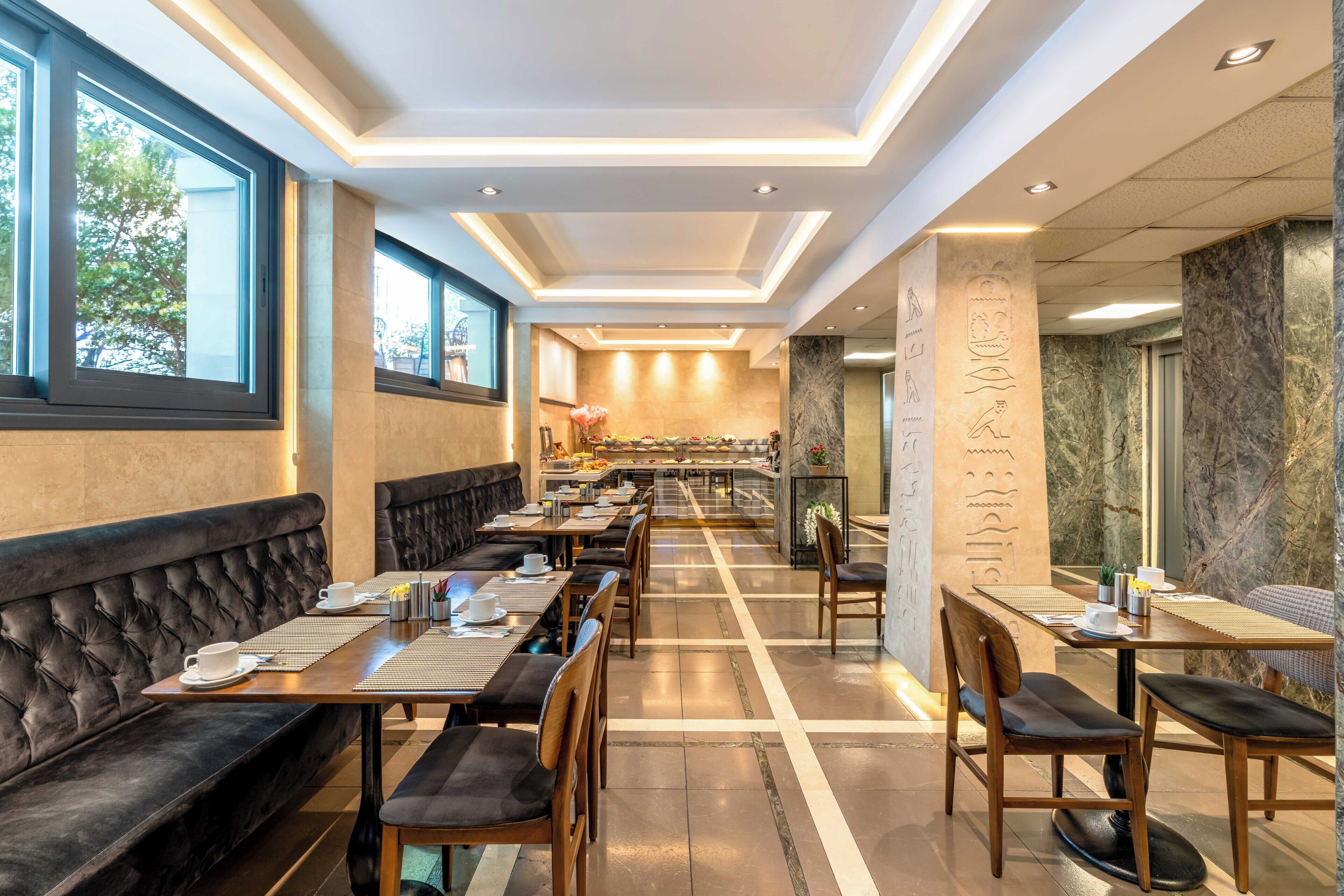 Un ristorante con un bancone lungo, posti a sedere riservati e una parete in marmo.