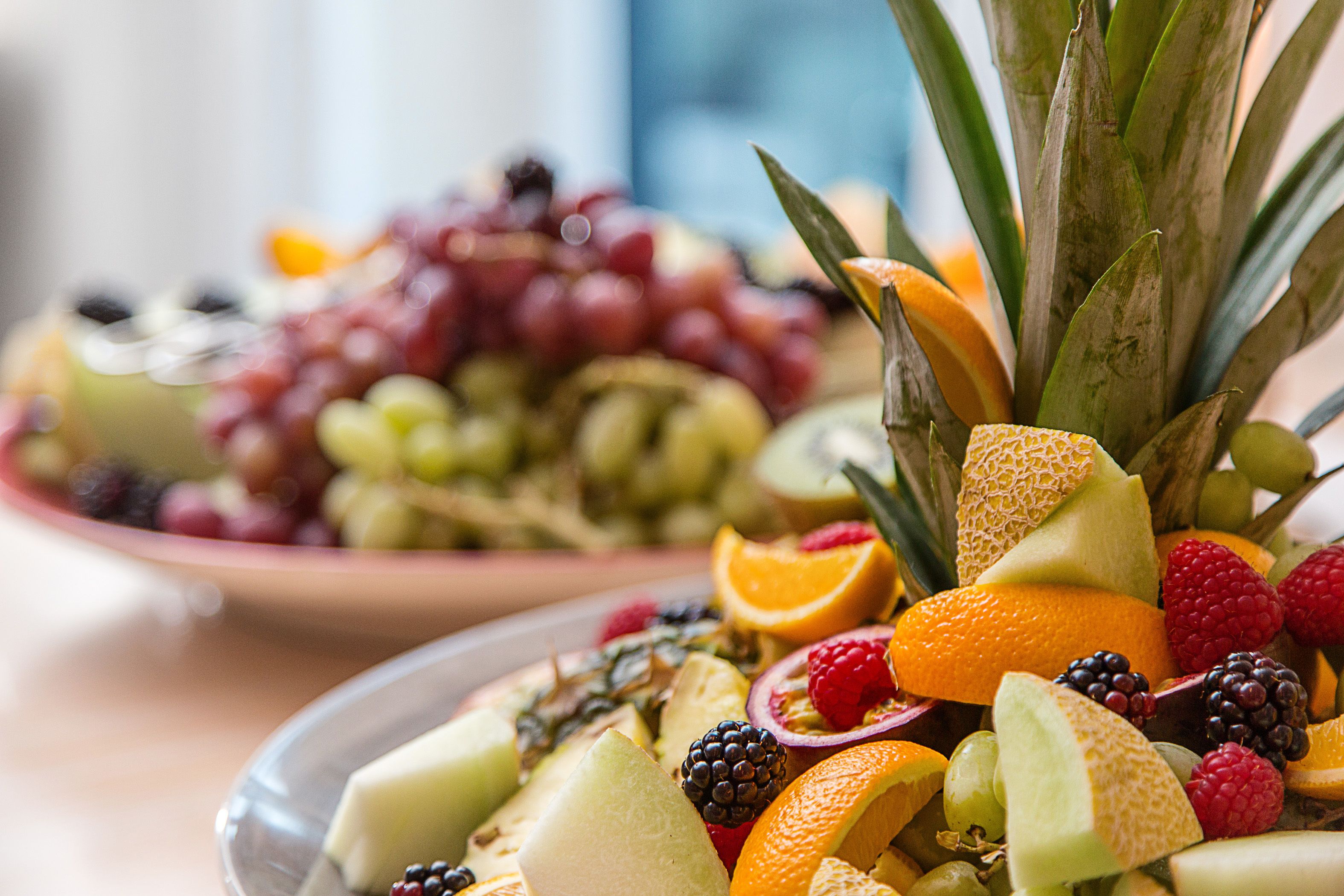 A fruit platter with various fruits including grapes, oranges, and berries.