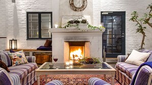 Una sala de estar acogedora con chimenea, sofás a rayas, una mesa de centro y un adorno decorativo en la pared.