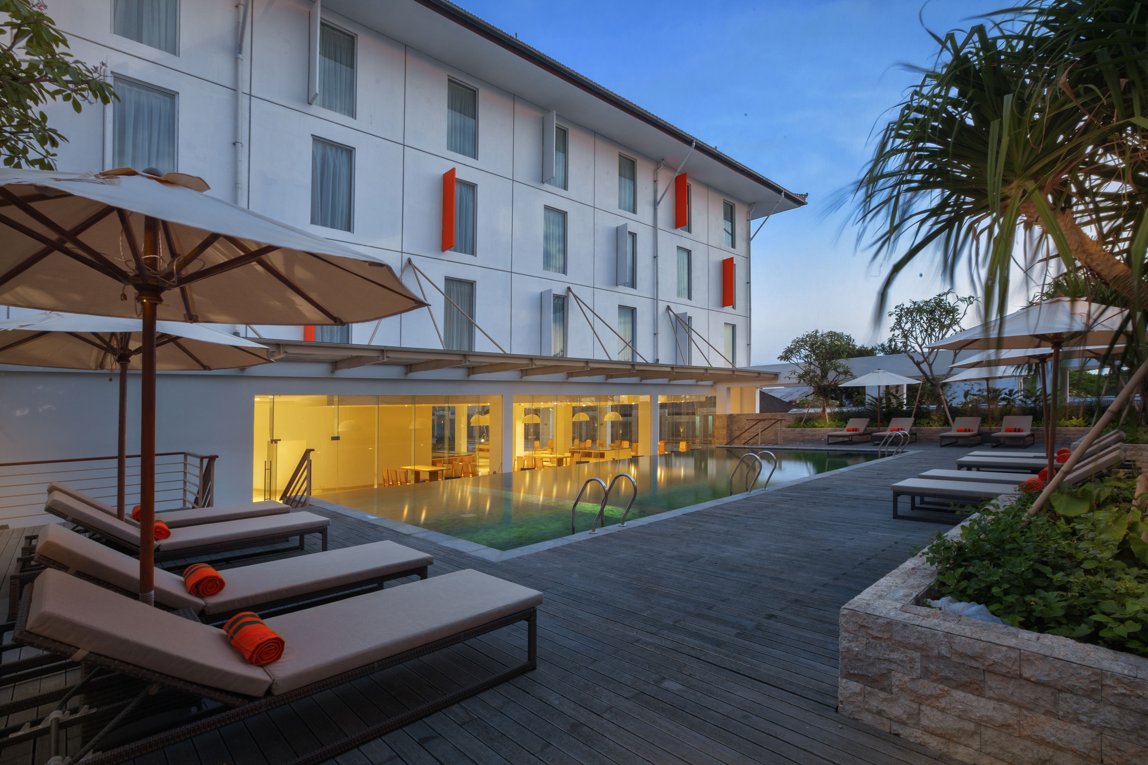 Un hôtel doté d’une piscine, de chaises longues et de parasols.