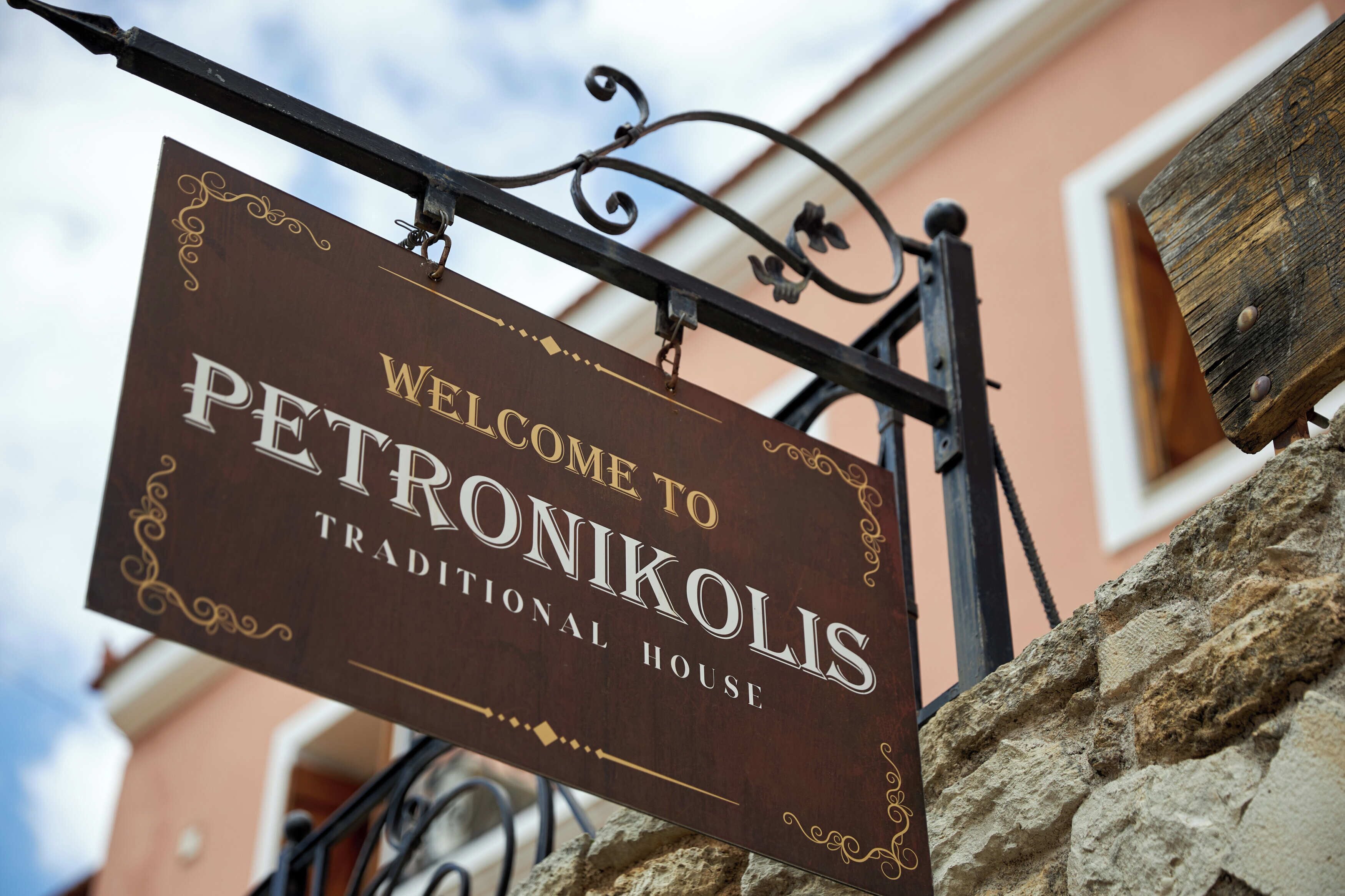 Een bord dat bezoekers verwelkomt bij Petronikos Traditional House.