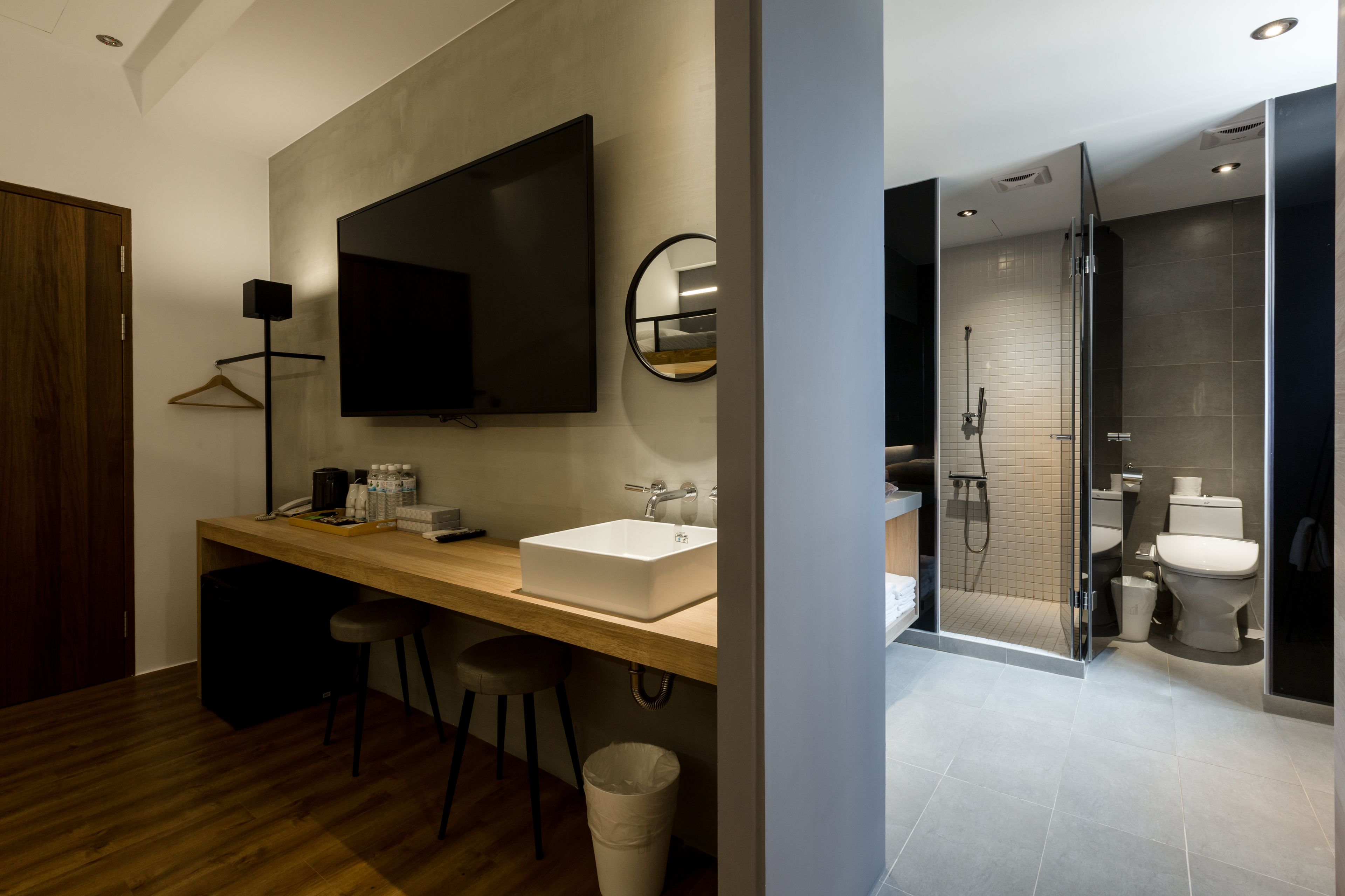 A modern bathroom with a large mirror, a sink, a toilet, and a shower area.