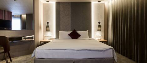 Una habitación de hotel moderna con una cama grande, un escritorio y una silla.