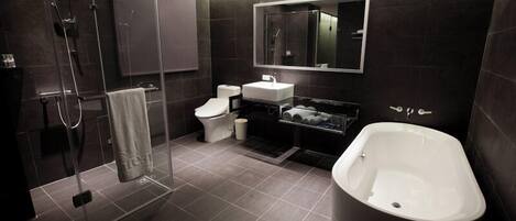A modern bathroom with a glass-enclosed shower, a white toilet, a sink, and a freestanding bathtub.