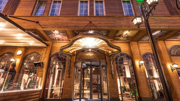 A hotel entrance with a revolving door, wooden facade, and decorative lighting. - Raymar Hotels Ankara (Ankara)