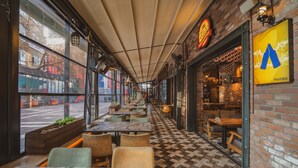 An indoor café with a long counter, wooden tables, and chairs. - Raymar Hotels Ankara (Ankara)