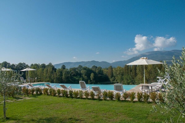 Een seizoensgebonden buitenzwembad en parasols bij het zwembad