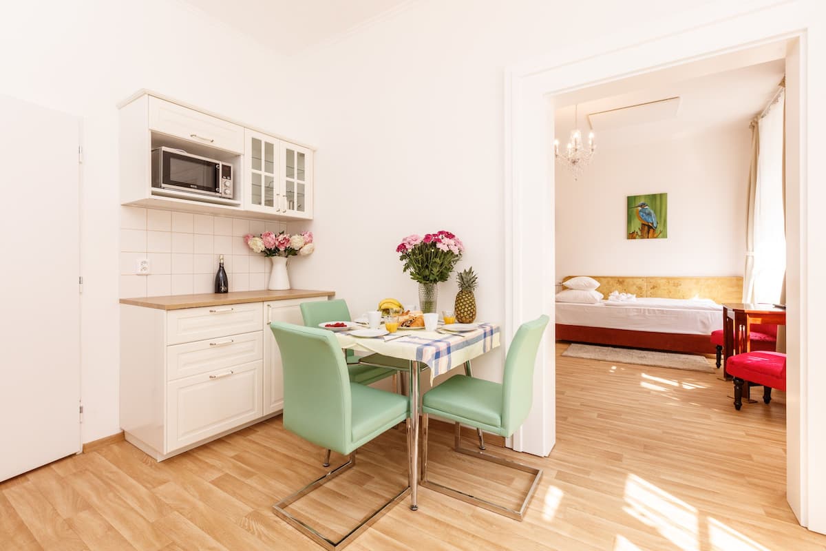 Um espaço compacto com cozinha compacta, área de jantar e um quarto.