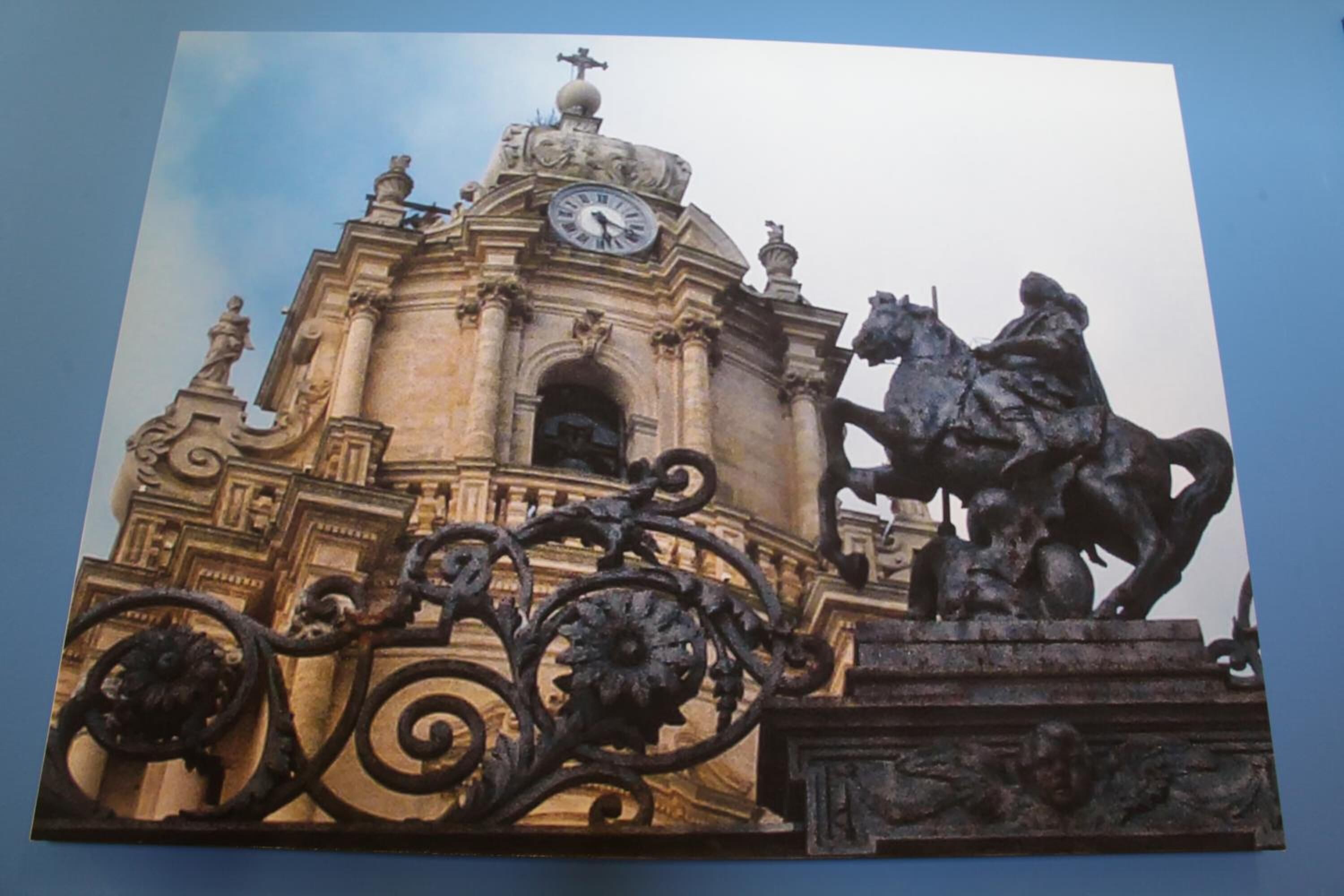 A building with ornate architecture, a clock, and a statue of a horse.