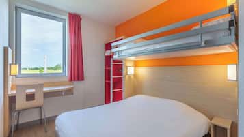 A hotel room with a bunk bed, a desk with a chair, a window with a view, and a bedside table.