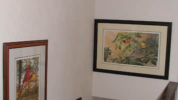 Una escalera con barandilla de madera y una pared decorada con cuadros.