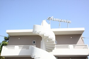A building with a unique spiral staircase and a sign that reads "Armonia." - Enorme Armonia Hotel (Malevizi)