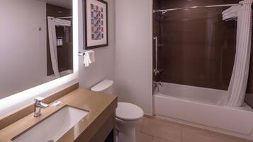 A modern bathroom with a sink, toilet, and bathtub.
